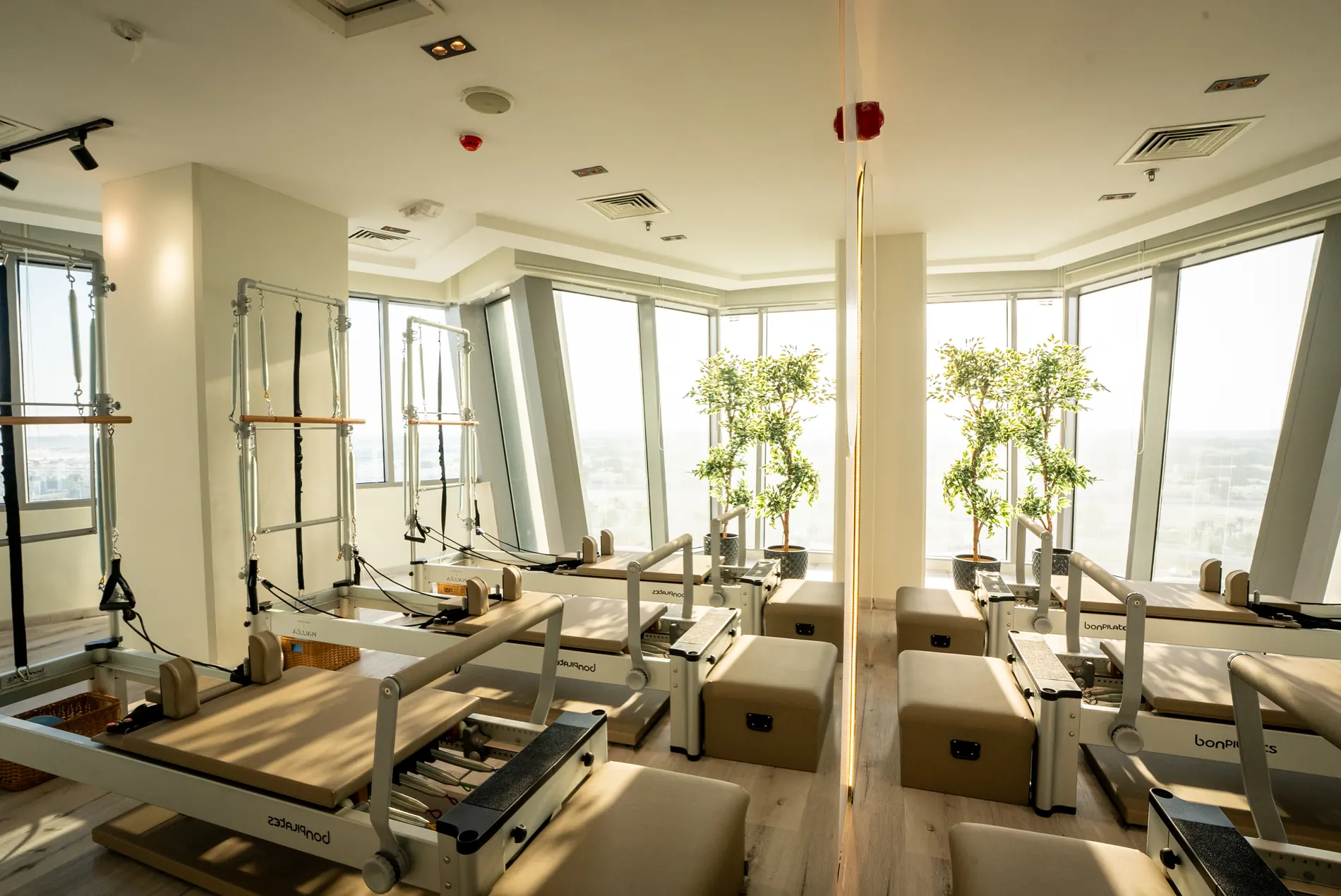 Reformer Pilates studio at Maison Kalléa in Lusail, with reformers facing floor-to-ceiling windows